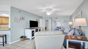Un salon avec un téléviseur, un ventilateur de plafond et un canapé.
