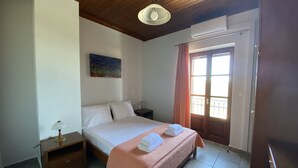 A bedroom with a bed, nightstand, and a painting on the wall. - Executive Villa Madouri With Private Pool (Lefkada)