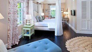 A bedroom with a bed, bedside table, lamp, and a window with curtains. - Leamington House  Summer Promotion | Near Ocean - Located in  Wonderful St. Peter with Private Pool (Little Battaleys)