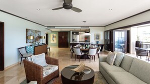 Un espacio habitable amplio con un sofá, sillas, una mesa de centro y un comedor con sillas y una mesa.