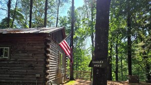 Una baita rustica con una bandiera americana, immersa in una foresta.