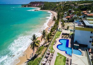 A resort with a beach, a swimming pool, and a view of the ocean.