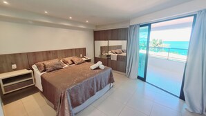 Un hotel moderno con una cama grande, una mesita de noche, un espejo y un ventanal corredero que da a un balcón con vistas al mar.