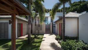 Un quartier résidentiel moderne avec un sentier en bois menant à une maison dont la porte est rouge.