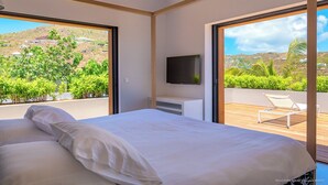 Une chambre moderne avec un grand lit, une télévision et un balcon équipé d’une chaise.