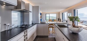Enjoy a scenic view from the central island with seating in this well-lit kitchen featuring a stove and oven.