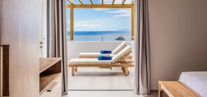 Enjoy a serene sea view from the window, where a wooden bench and table invite relaxation.