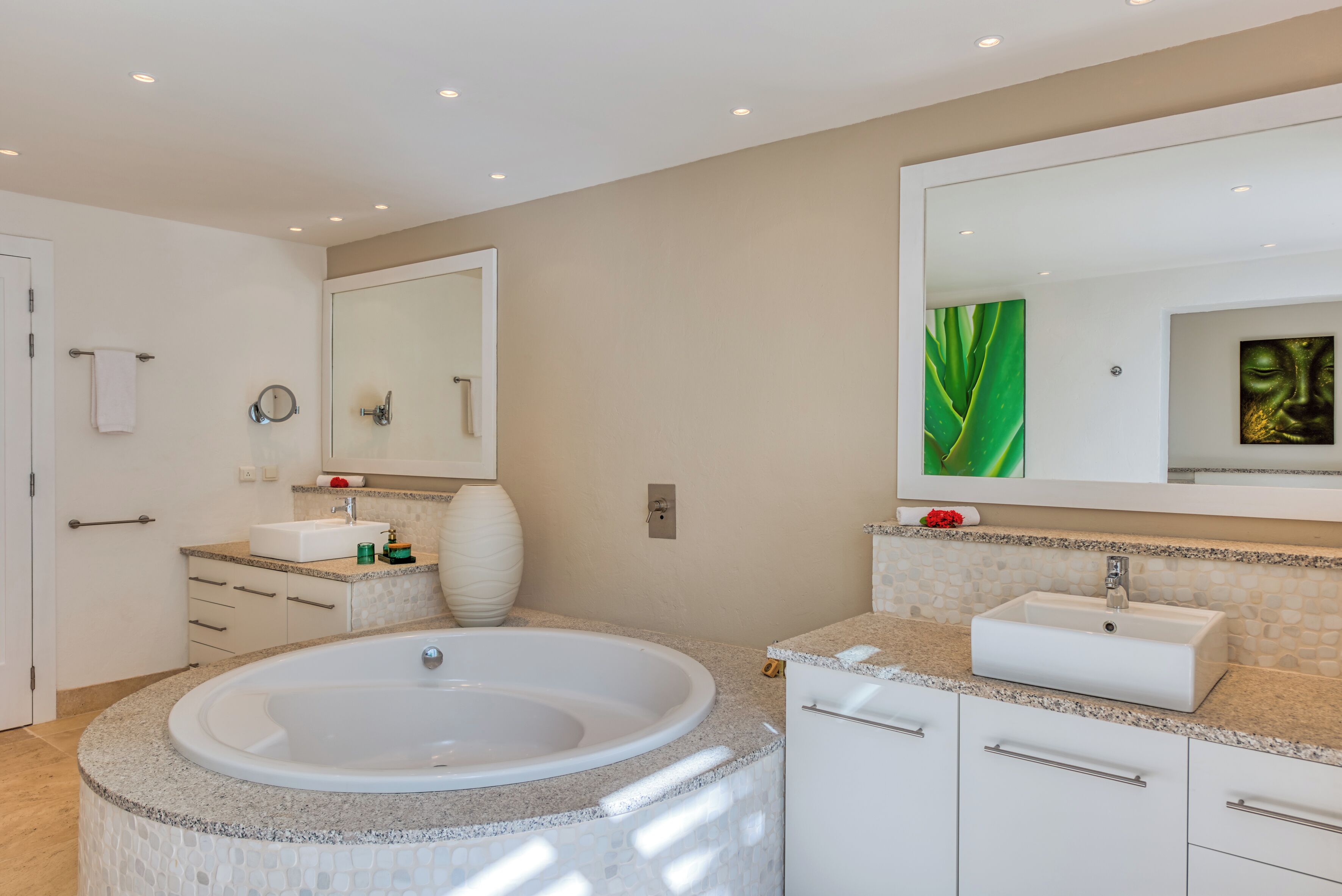 A modern bathroom with a freestanding bathtub, a large mirror, and a vanity with a sink.