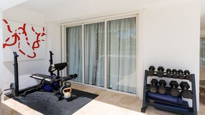 A home gym with a stationary bike, a treadmill, a kettlebell, and a rack of dumbbells. - Villa Bamboo | Ocean View - Located in  Wonderful Terres Basses with Private Pool (Les Terres Basses)