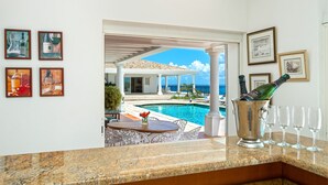 Une chambre luxueuse avec piscine, des œuvres d’art encadrées et un seau à champagne.