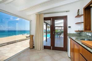 Une cuisine moderne avec vue sur la plage et la piscine.