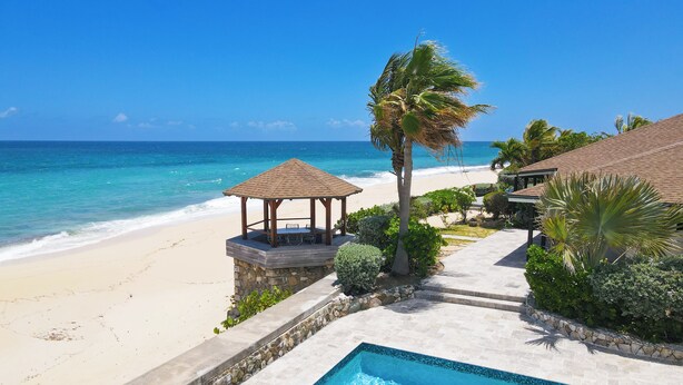 A beachside pool with a gazebo, palm trees, and a view of the ocean. - Villa Blue Beach  | Beach Front - Located in  Stunning Baie Longue with Private Pool (Les Terres Basses)
