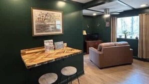Une pièce comprenant un coin bar, un canapé et un tableau au mur.