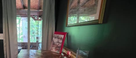 Une pièce dotée d’un parquet en bois disposé en motif de chevron, d’une affiche encadrée au mur et d’une fenêtre avec des rideaux.