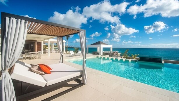 A poolside area with a cabana, lounge chairs, and a view of the ocean. - Villa Turtle Nest  | Beach Front - Located in  Magnificent Baie Longue with Private Pool (Les Terres Basses)