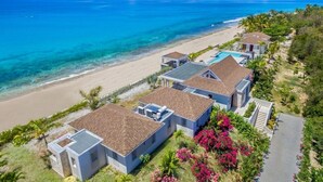 A beachfront property with multiple villas, a swimming pool, and a beach view. - Villa Turtle Nest  | Beach Front - Located in  Magnificent Baie Longue with Private Pool (Les Terres Basses)