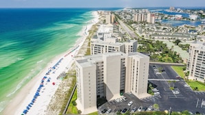 A high-rise hotel with a beach view, parking lot, and a marina in the background. - 🌴Gulf Front~ Free Seasonal Beach Chairs -2BR Shoreline Towers 1035 (Destin)