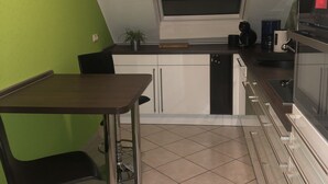 A compact kitchen with a window, a dining area, and a built-in oven.