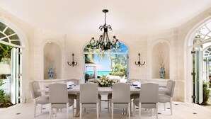 Un'area pranzo con un tavolo grande, sei sedie, un lampadario e vista sull'esterno.