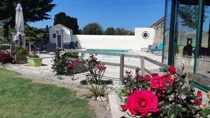 A pool area with a white wall, a clock, and outdoor seating. - Townhouse 12 persons LE DOMAINE DES PAONS 4 ETOILES (Saint-Germain-du-Pert)
