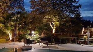 An outdoor patio area with seating, a pool, and surrounding greenery. - Townhouse 12 persons LE DOMAINE DES PAONS 4 ETOILES (Saint-Germain-du-Pert)