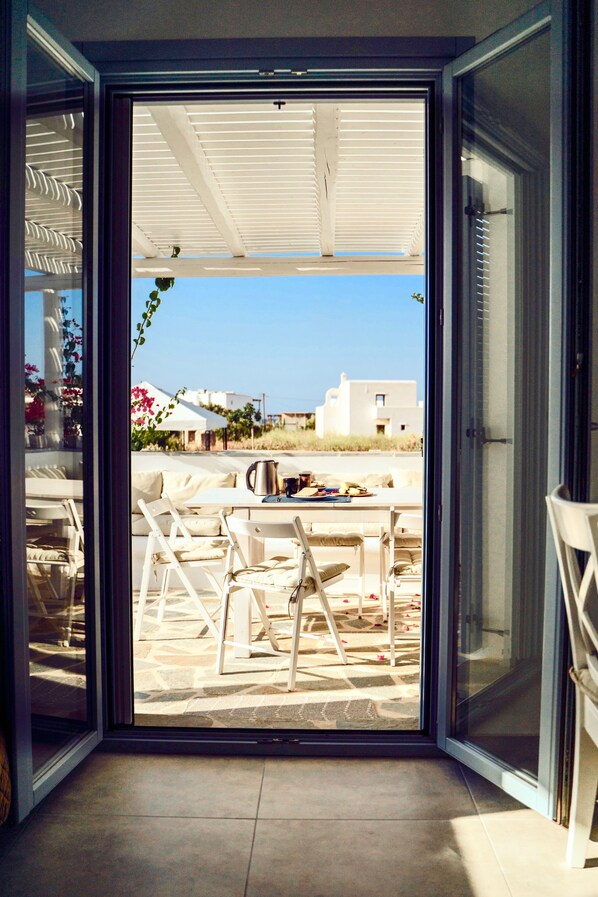 A modern room with a sliding glass door leading to an outdoor patio area. - VILLA PERGOLA, a private villa with a private pool and an incredible view. Quiet neighborhood. (Naxos)