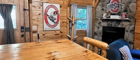 Un intérieur en bois avec une cheminée en pierre, une table et un canapé.