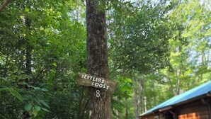 Ein Holzschild an einem Baum mit dem Schriftzug 'SETTLERS BOOST 8'.