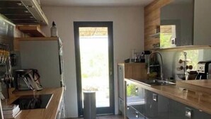 Eine Küche mit Holzausstattung, einem Spülbecken und einem Fenster.