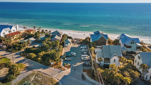 A coastal residential area with houses, a parking lot, and a beach. - Escape to Blue Mountain Beach – GOLF CART, Pool, Gym & Rec Courts (Santa Rosa Beach)