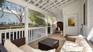 A covered patio with wicker furniture, a ceiling fan, and a view of a house and trees. - Escape to Blue Mountain Beach – GOLF CART, Pool, Gym & Rec Courts (Santa Rosa Beach)