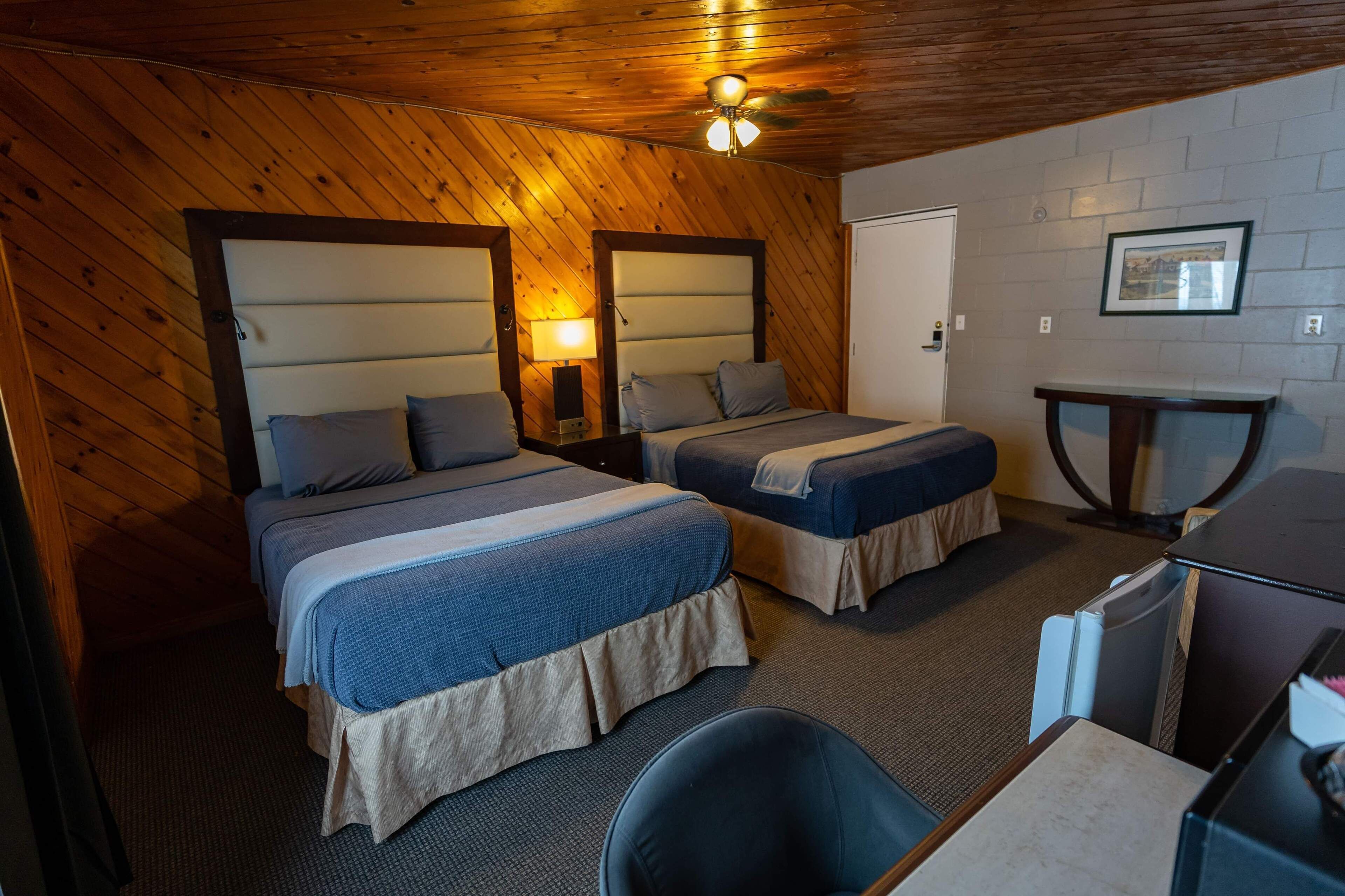 Une chambre avec deux lits, un bureau et une chaise.