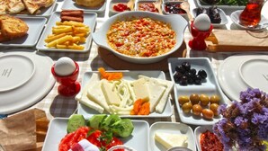 A table set with various dishes including bread, cheese, olives, and a salad. - Bozcaada Teras Otel (Bozcaada)