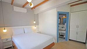 A bedroom with a bed, bedside tables, a wardrobe, and a bathroom visible through an open door. - Bozcaada Teras Otel (Bozcaada)
