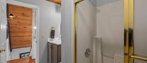 A bathroom with a shower, toilet, and sink.