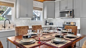 A dining area with a wooden table set for six, surrounded by patterned chairs. - Smoky Mountain Cabin with Stunning National Park Views (Gatlinburg)