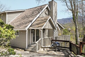 Ein Haus mit Veranda, Schornstein und Blick auf die Berge.