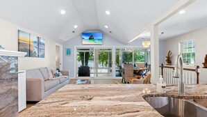 A spacious living area with a large kitchen island, a sofa, and a dining area with chairs. - Riverfront Home on the Ohio River, Private Dock, Hot Tub, Sleeps 8 (Prospect)