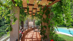 A covered walkway with a pool in the background. - Villa Lombrici, at Mount Camaiore foot, near to the beach with private pool (Camaiore)