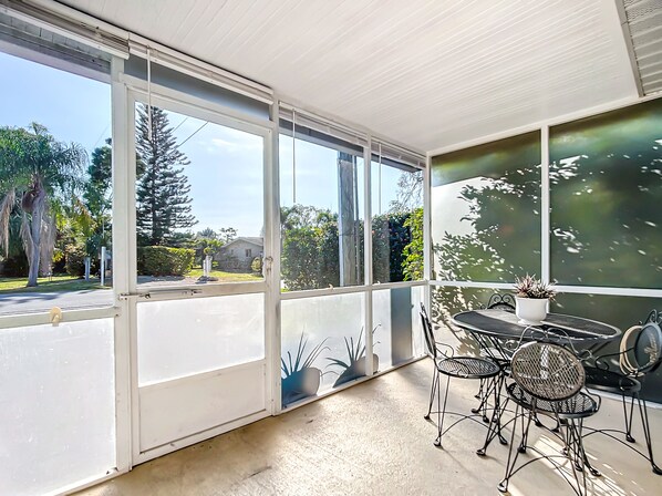 A sunlit room with large windows, a round table, and four chairs. - Quiet Riverside Cottage in Downtown Bonita Springs (Bonita springs)