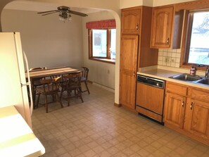 Enjoy meals in this kitchen with a dishwasher, dining table, and window with a view.