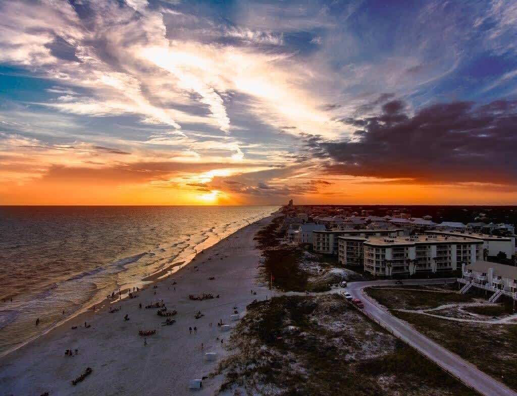 A coastal view with a beach, ocean, and buildings.