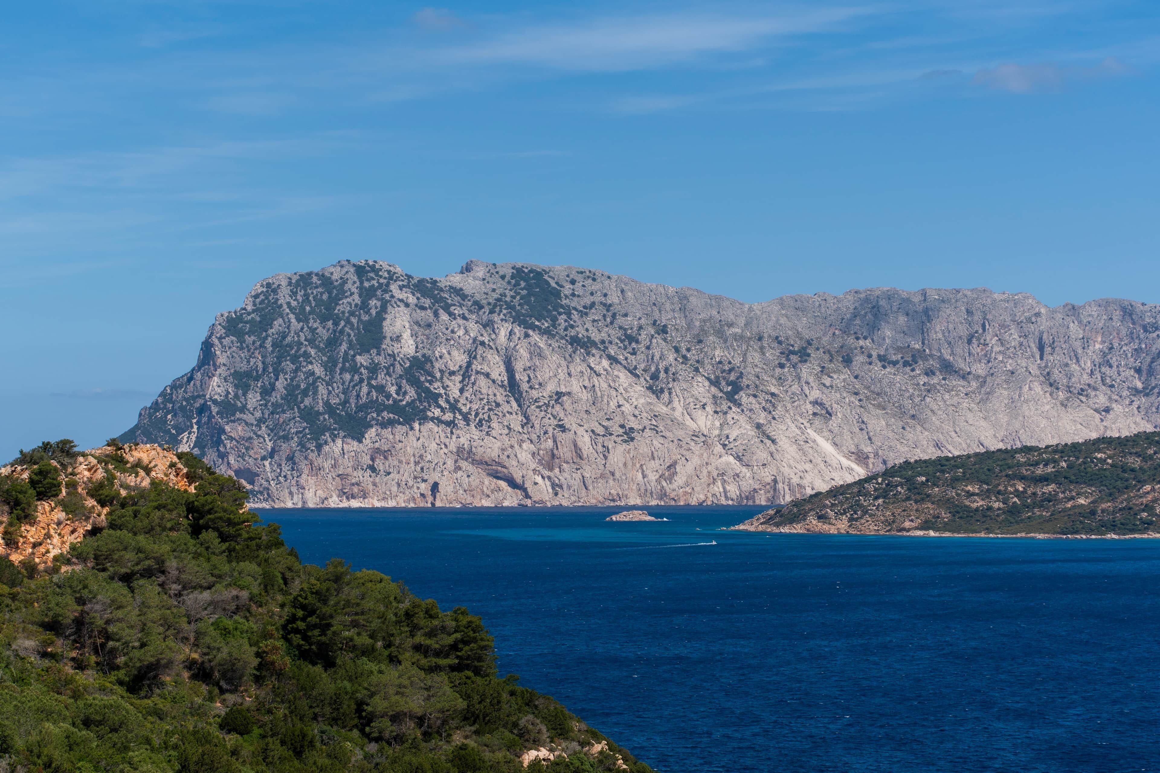 A mountainous landscape with a clear blue sea.