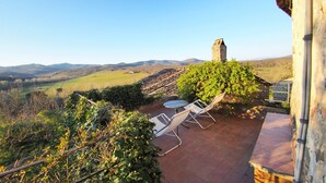 A patio with a table and chairs overlooking a vineyard and distant hills. - Castello di Montalto - Casa del Guardia (Castelnuovo Berardenga)
