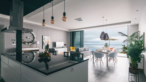 A modern kitchen with a central island, a dining area with a view, and a living space with a large window overlooking the ocean. - Villa Brava Atlântico (Ribeira Brava)