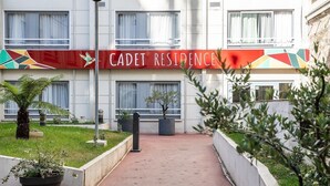 Un immeuble sur lequel on peut lire l’inscription « RÉSIDENCE CADET », et un chemin menant à l’entrée.