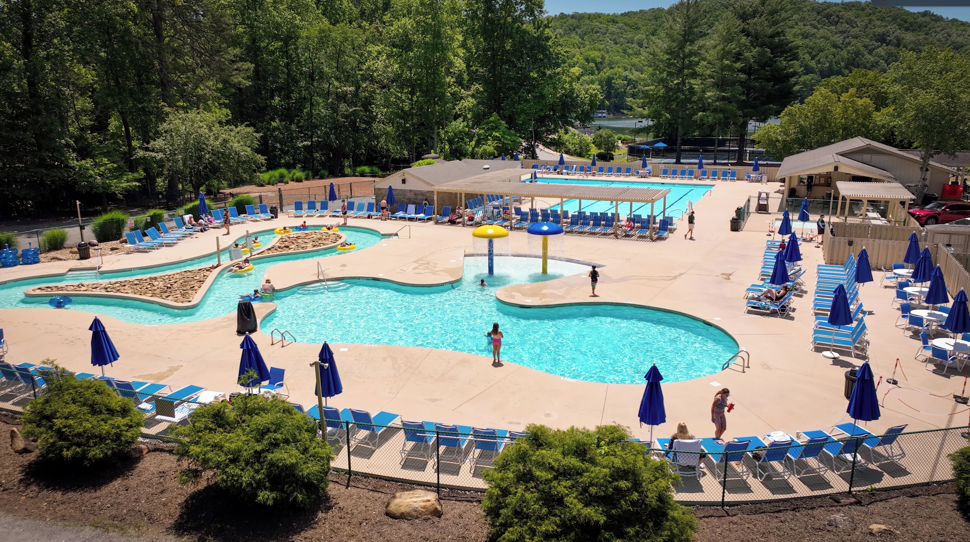 A pool area with multiple swimming pools, lounge chairs, and umbrellas.