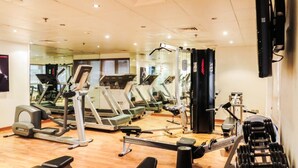 A gym with treadmills, elliptical machines, and weight benches. - The Uptown Apartments Abu Dhabi by Gewan (Abu Dhabi)