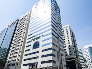 Un edifici alt amb un disseny arquitectònic modern, amb una finestra en arc pronunciada i una sèrie de balcons.