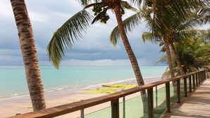 A beach with palm trees and a wooden walkway.